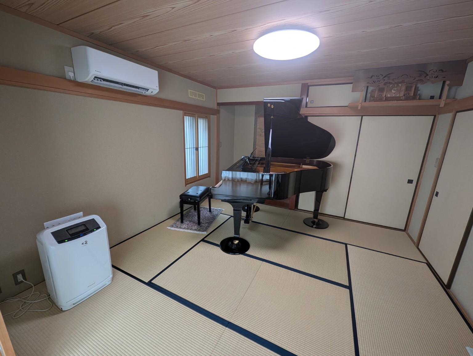 広く明るい和室にグランドピアノが置かれたレッスン室